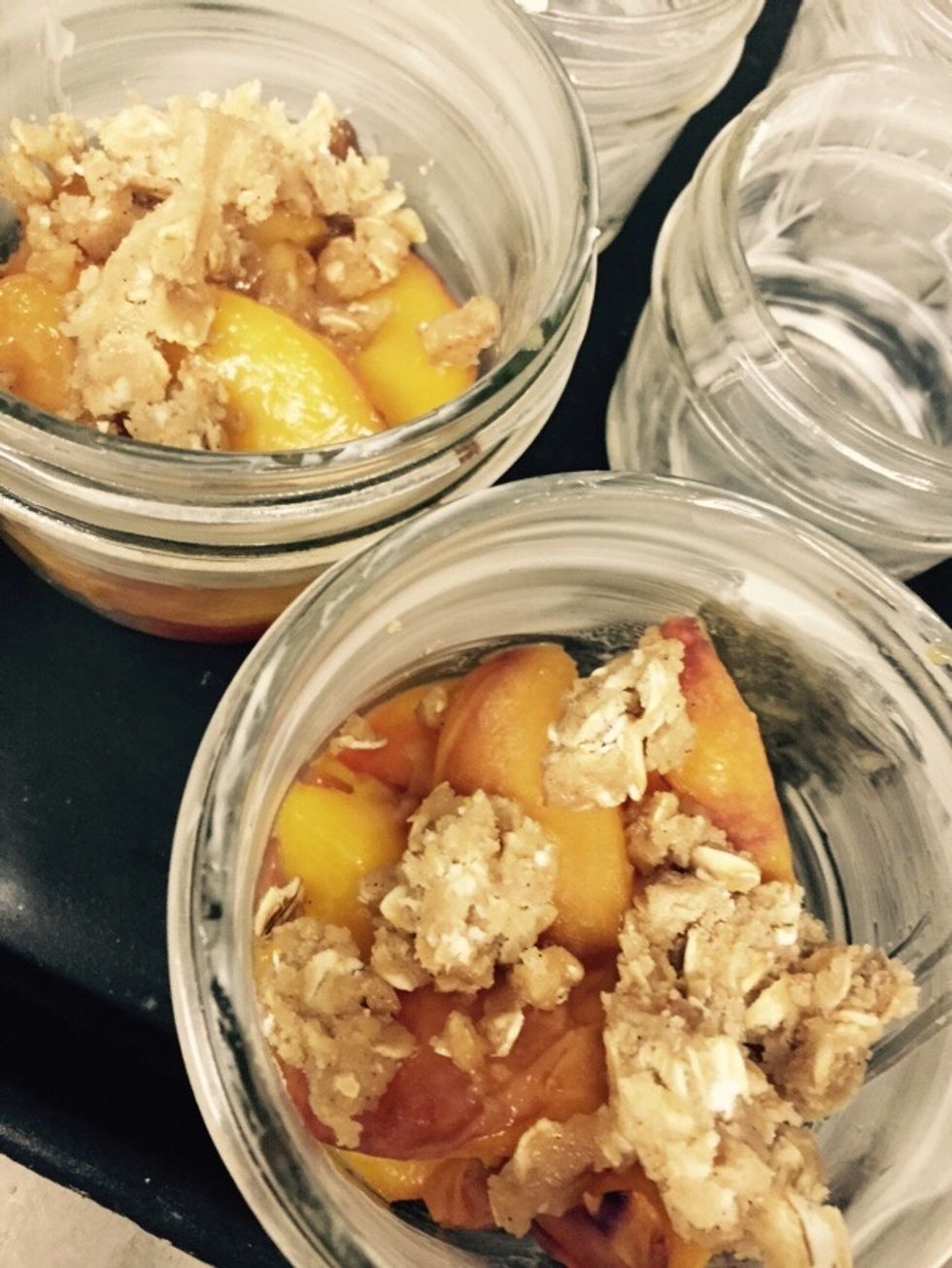 Fill cups half way with peaches and add crumble.
