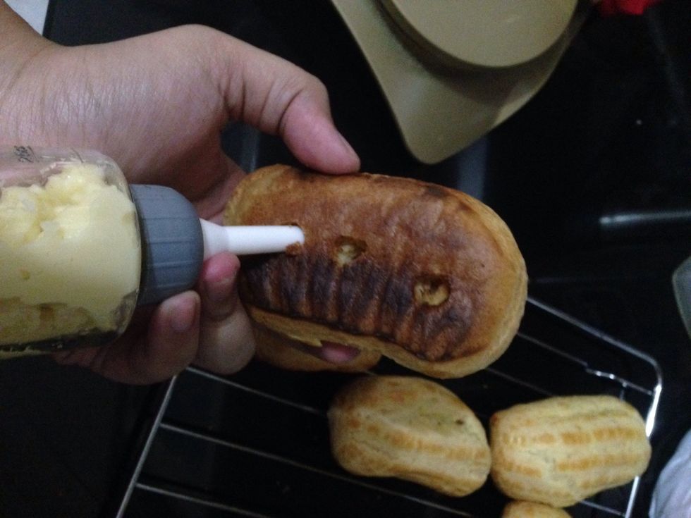 Fill eclairs with the pastry cream from 3 holes at the bottom that we've made before. Fill it until the inside becomes full and feels heavier