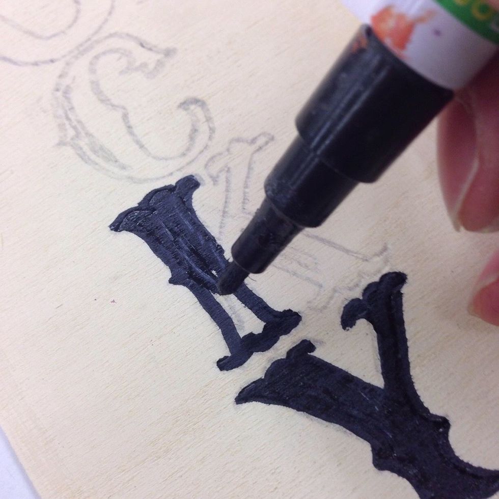 Fill in the traced L, C, K and Y with black paint. If you have steady hands, use a brush and black paint. Otherwise, a black paint pen works great for this part!