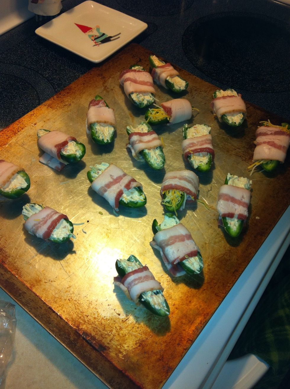 Fill jalape\u00f1os, slice bacon into smaller strips, wrap and place on baking sheet