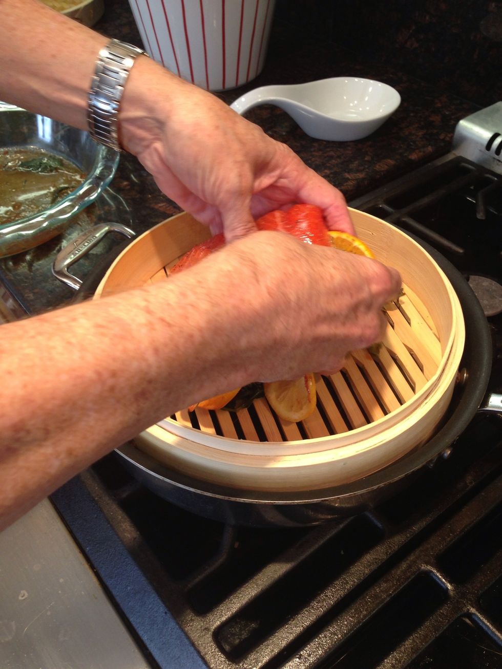 Fill saut\u00e9 pan with water and place Japanese steamer on top. Place salmon atop steamer, with lemons and herbs. Steam for about 10 minutes (depending on thickness) until salmon is tender to the touch.