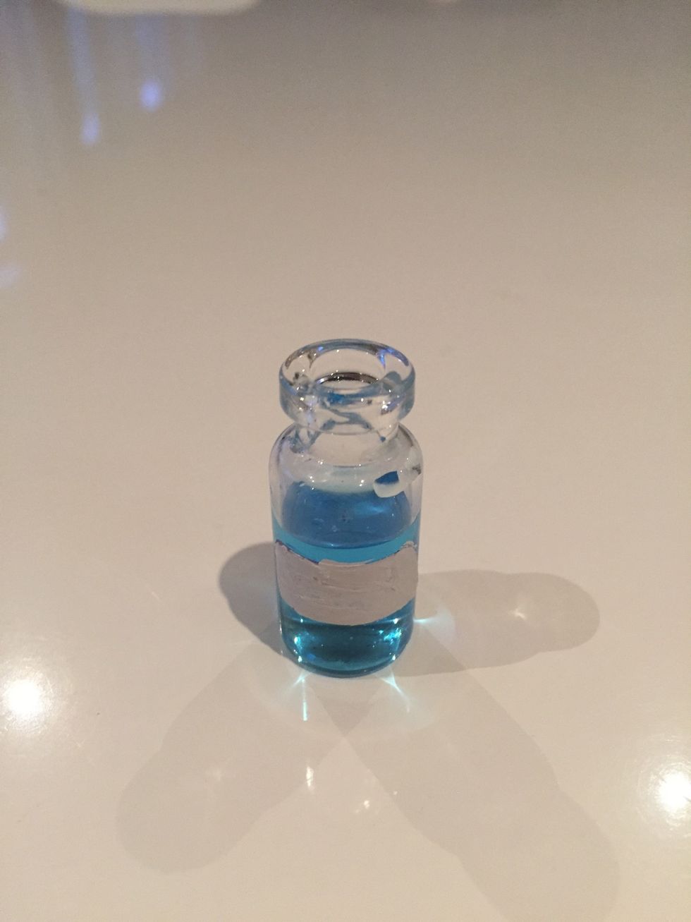 Fill the bottle with the blue water then take a little label sticker and place it on the front and in the middle of the glass bottle