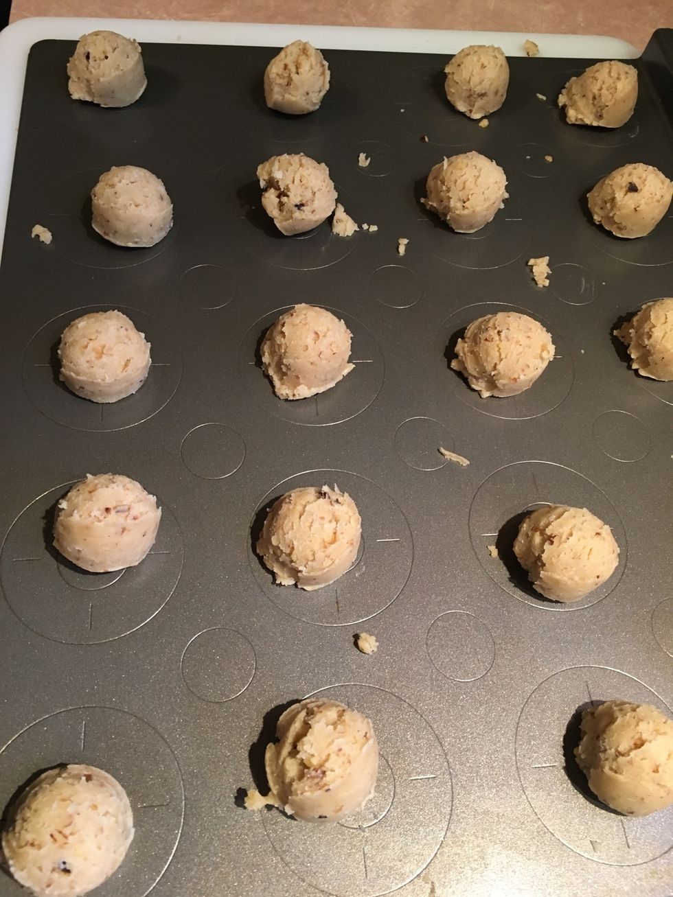 Fill the cookie sheet with portioned cookie dough. Now we will shape the dough balls into crescents.