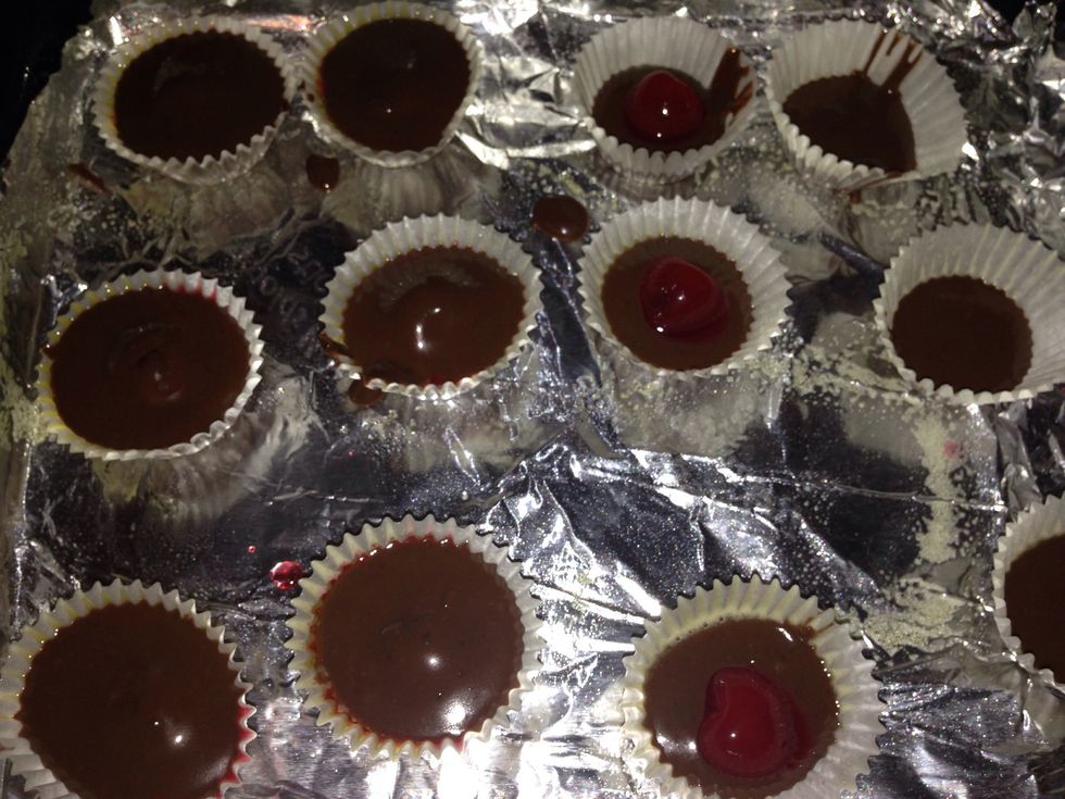 Fill the cups 1/2 way with the melted chocolate, then place a cherry in the center and fill the remainder of the cup with chocolate