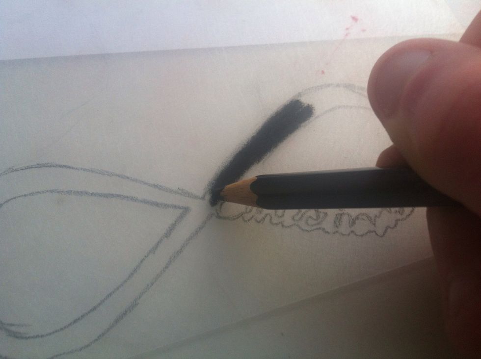Fill the outline shape with a coloured pencil. Make sure you press quite firmly. There should be no gaps showing on the other side of the plastic.