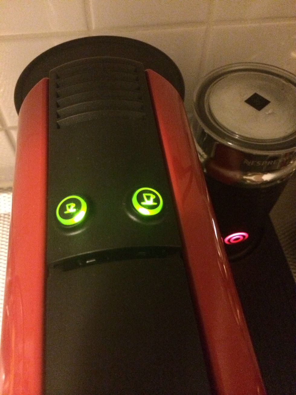 Fill up the watertank and press one of the buttons on the machine to turn it on.