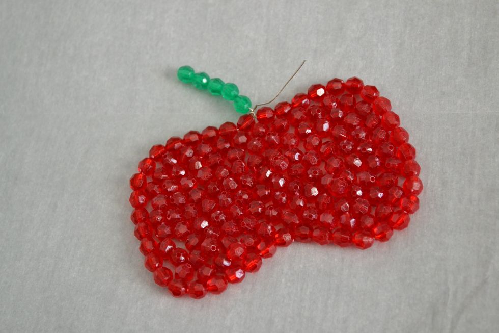 Fill your "mold" with the remaining red or green beads until the center is full. Make sure you have most of the gaps filled and also make sure that your wire is as flat as possible.