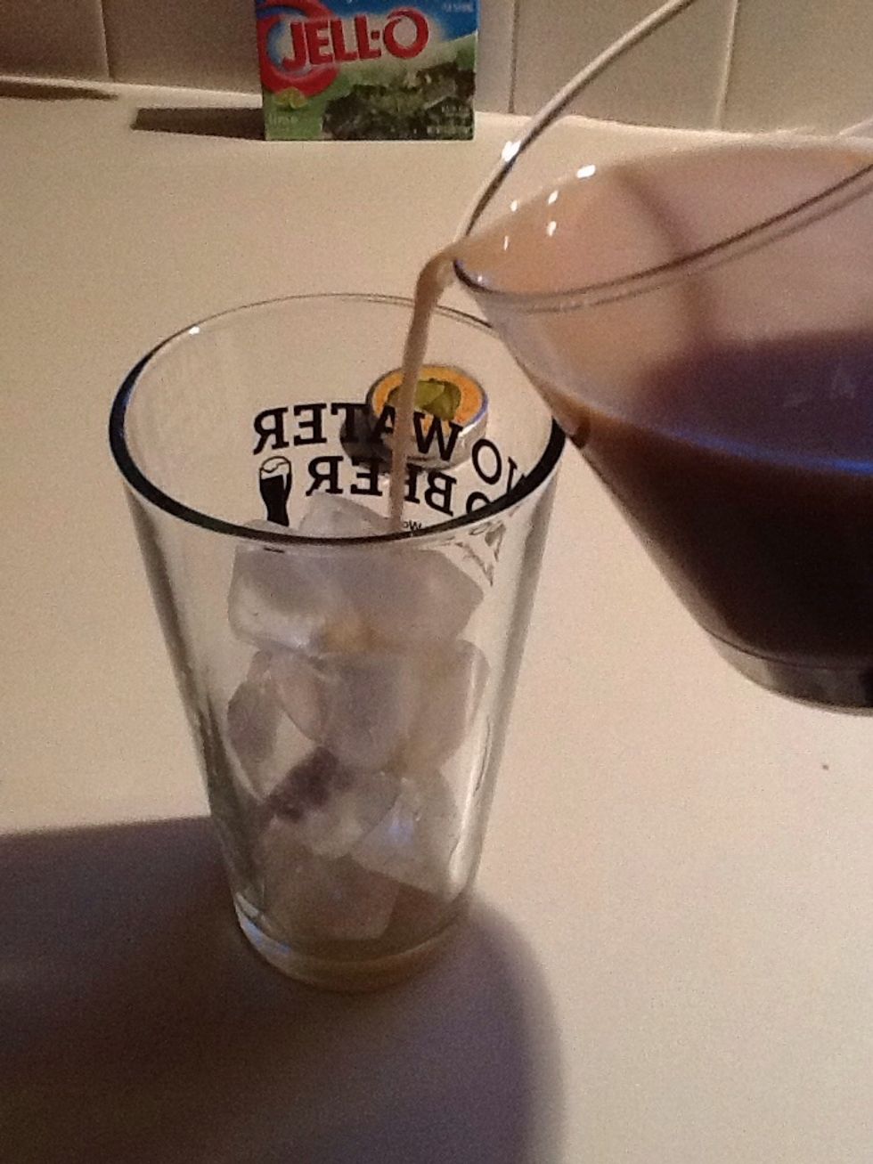 Fills cup halfway with ice and pour in the coffee.
