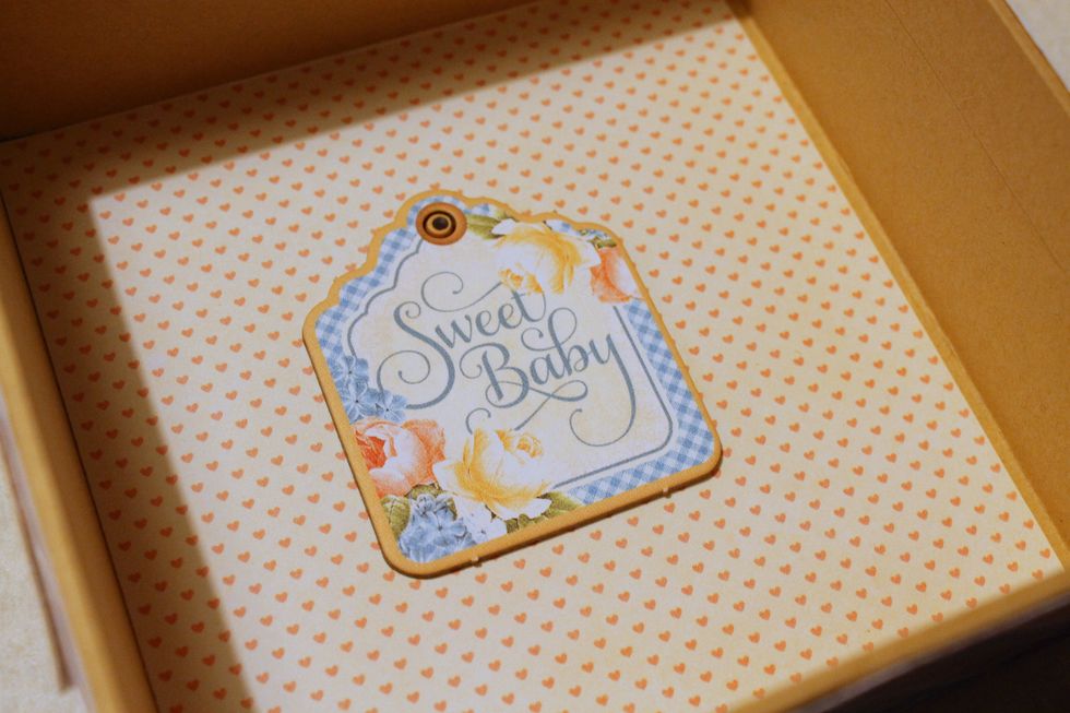 Finally, cover up the inside of the box with white paper with hearts on it and a chipboard tag.