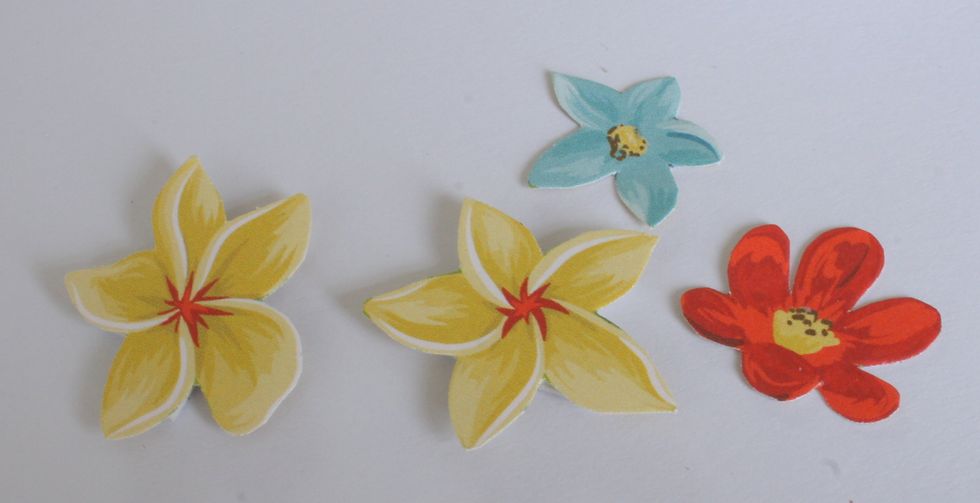 Finally, cut out four flowers from the "Beach Therapy" paper. Attach two flowers on your card with foamtape and attach the other two flowers with tissue tape. Also add pearls to the flower centers.
