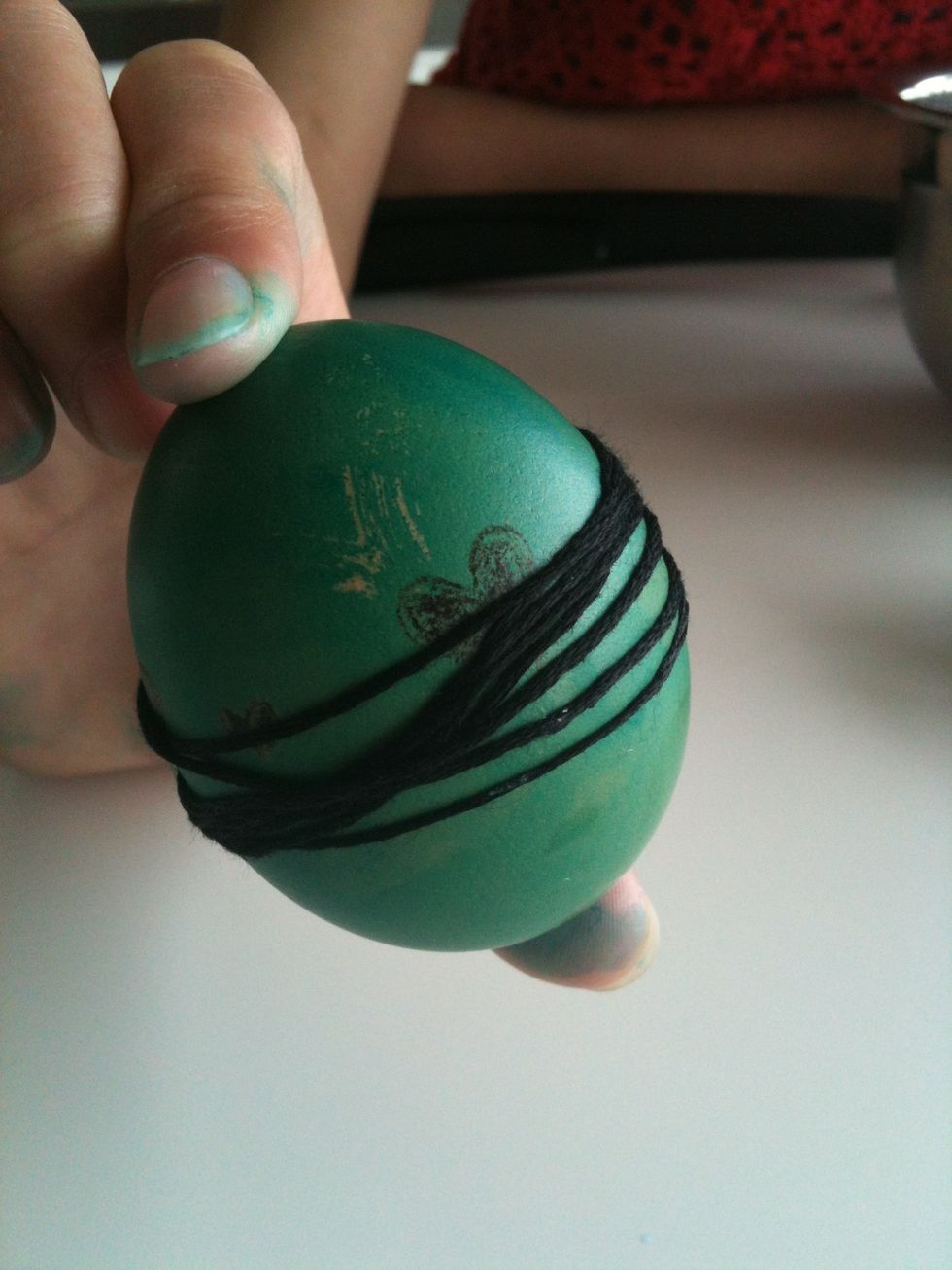 Finally decorate your dyed egg with string.