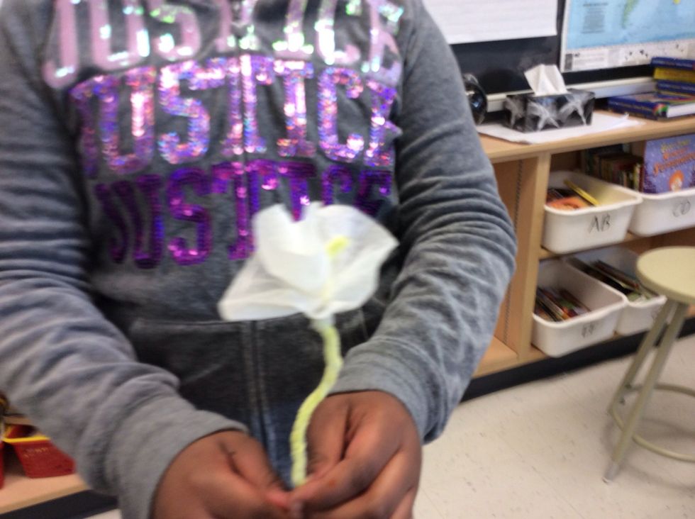 Finally , take a long piece of tape and tape the end of the flower onto the pipe cleaner .