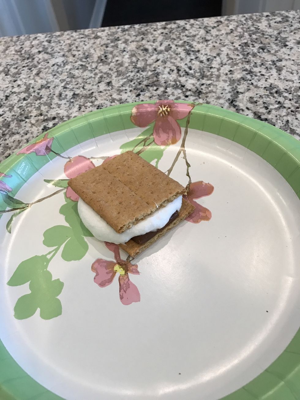 Finally take the marshmallow off the stick, put on the graham crackers and add the chocolate. Make it like a sandwich. Enjoy your smore.