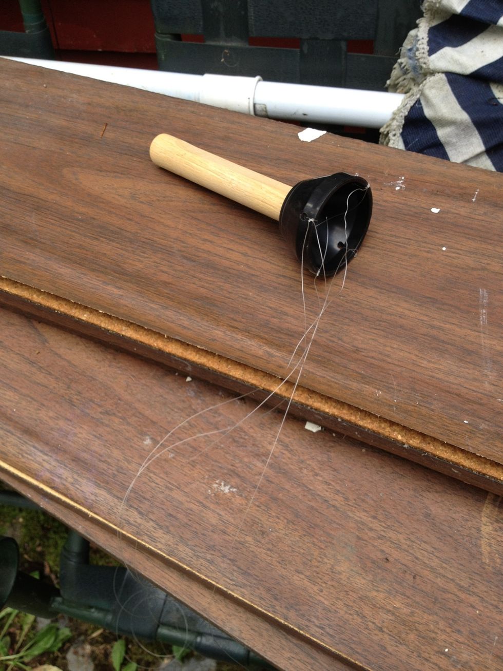 Find a plastic ring and attach a wooden dowel to the inside then drill four holes around the edge of the ring and tie fishing wire to each hole