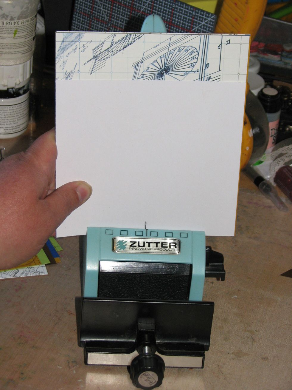 Find the center of your inside pages and align it with the given mark on the cutter. I am using a piece of scrap cardstock to use as a guide.