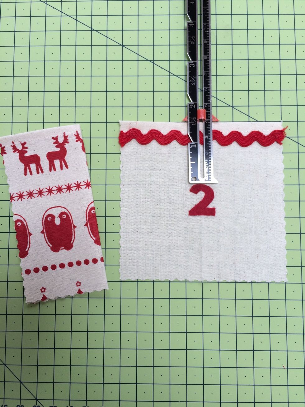 Find the centre of each pocket . Peel off the paper and iron the felt numbers in place , 1.5 inches down from pocket top
