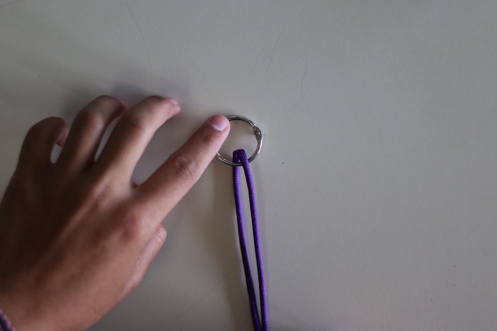 Find the middle of the cord and put the key ring in the middle of the cord.