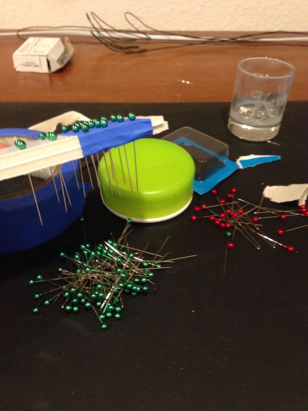 Find two pieces of excess board. Tape them together and push your pins through this new device.