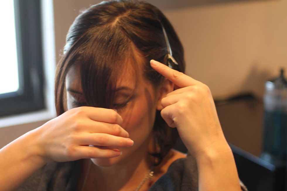 Find your cowlick. Hold your bangs horizontally with two fingers, lightly pushing up. The hair will split where your cowlick is \u2014 consider this when you cut.