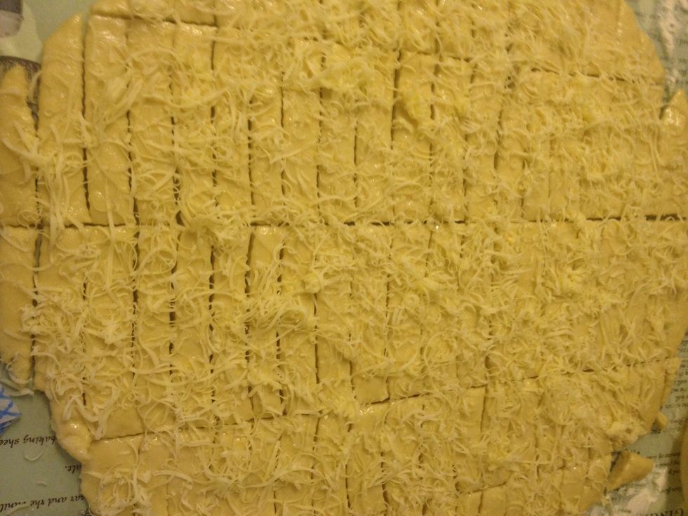 Fine grate some more cheese. Do them fresh on the top of the dough to avoid sticking the grates together. Add as much as you like, rather hard cheese like cheddar, or smoked cheese for flavour!