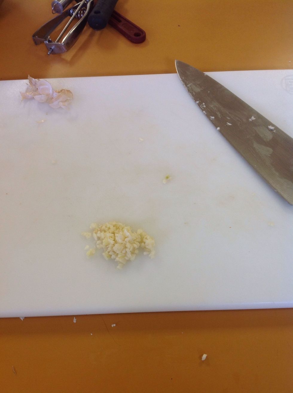 Finely mince the garlic clove using the proper cutting technique learned in class.