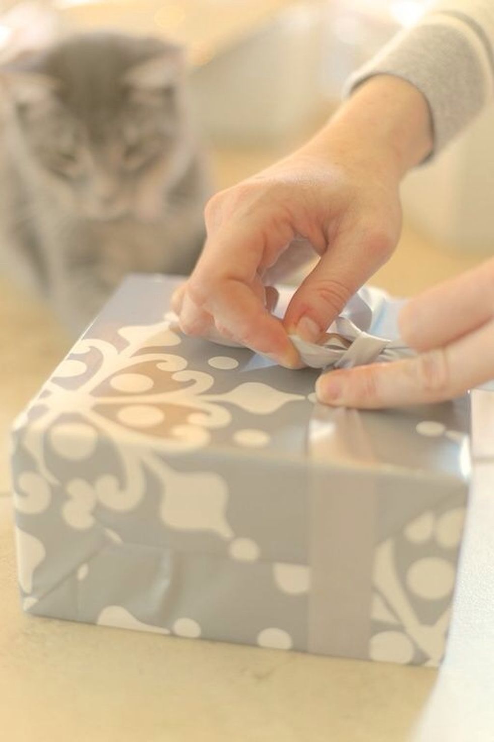 Finger aerobics! While holding the knot, start to make a bow. Make sure that the satin side of the ribbon is facing out on the "ears". This may take twisting the ribbon once. Tighten.