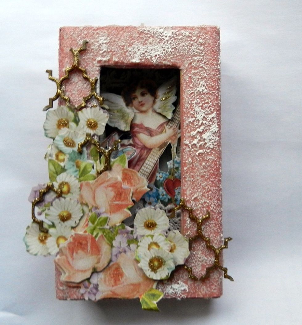 Finish by adding the pieces of chipboard and applying gold glitter in them.