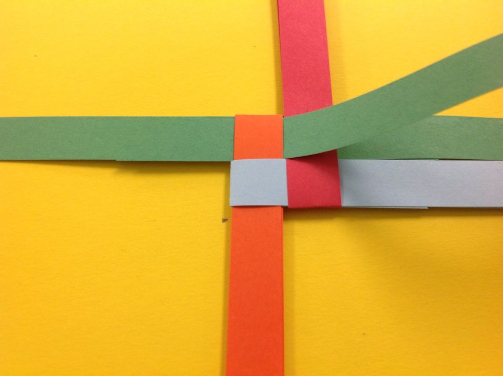 Finish by taking the top left strip (orange) and folding down and through the opening created by the blue.