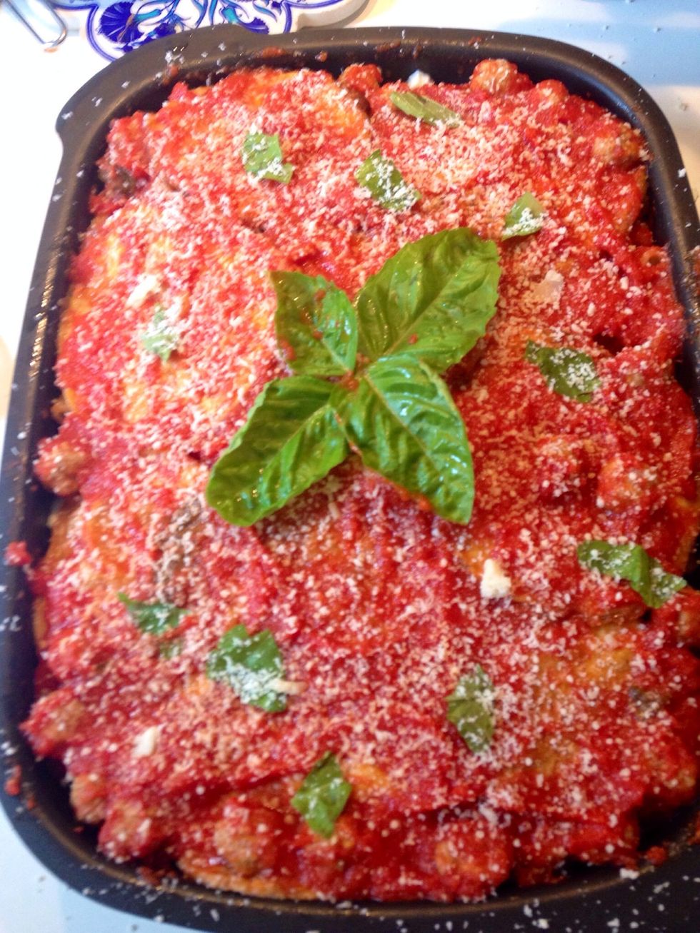Finish cooking in the oven at 180 celsius degrees for 30 minutes, then decor with basil leaves and grated parmesan. Serve at least 30 minutes after taking the tin out of the oven. Enjoy it!