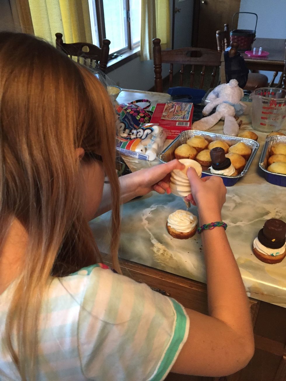 Finish frosting & put cookie w/ marshmallow on top of frosting for the hat - we decided to wait on putting cookies on top until ready to leave to cut back on flattening the frosting...