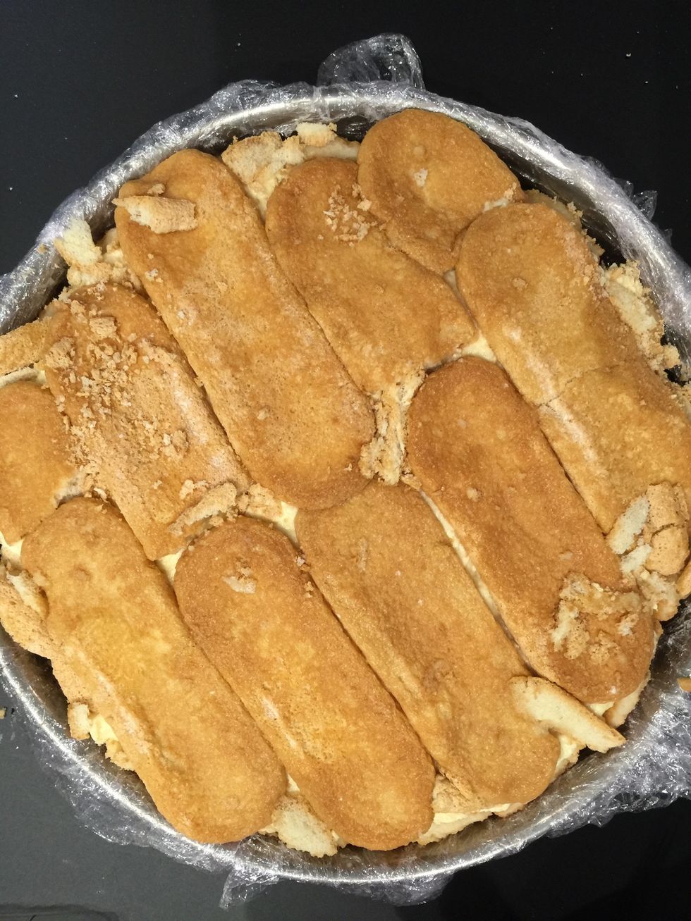 Finish with a layer of biscuits dipped in orange juice