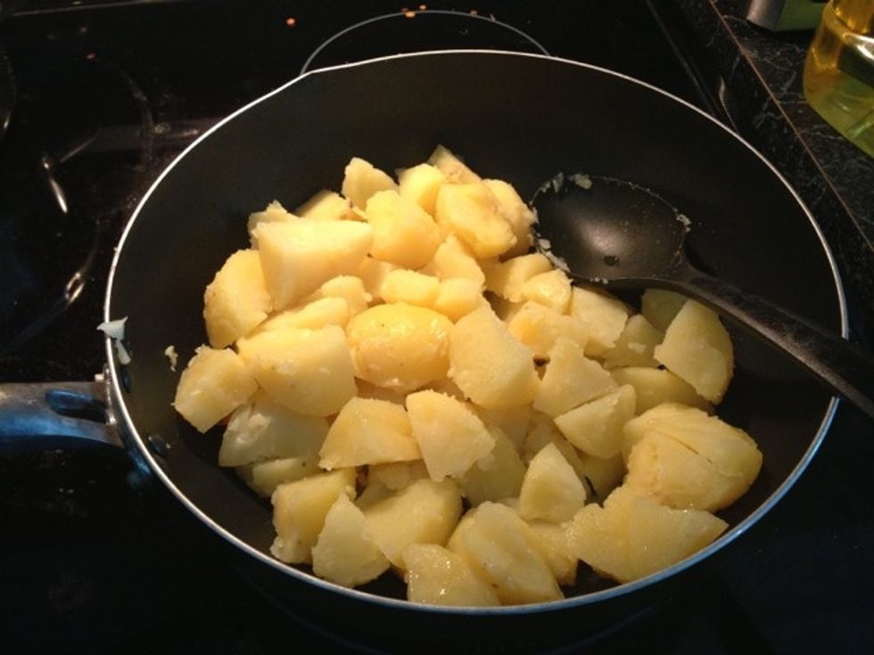 First add two tablespoon oil and two tablespoon ghee to kadai and then add the diced potatoes.