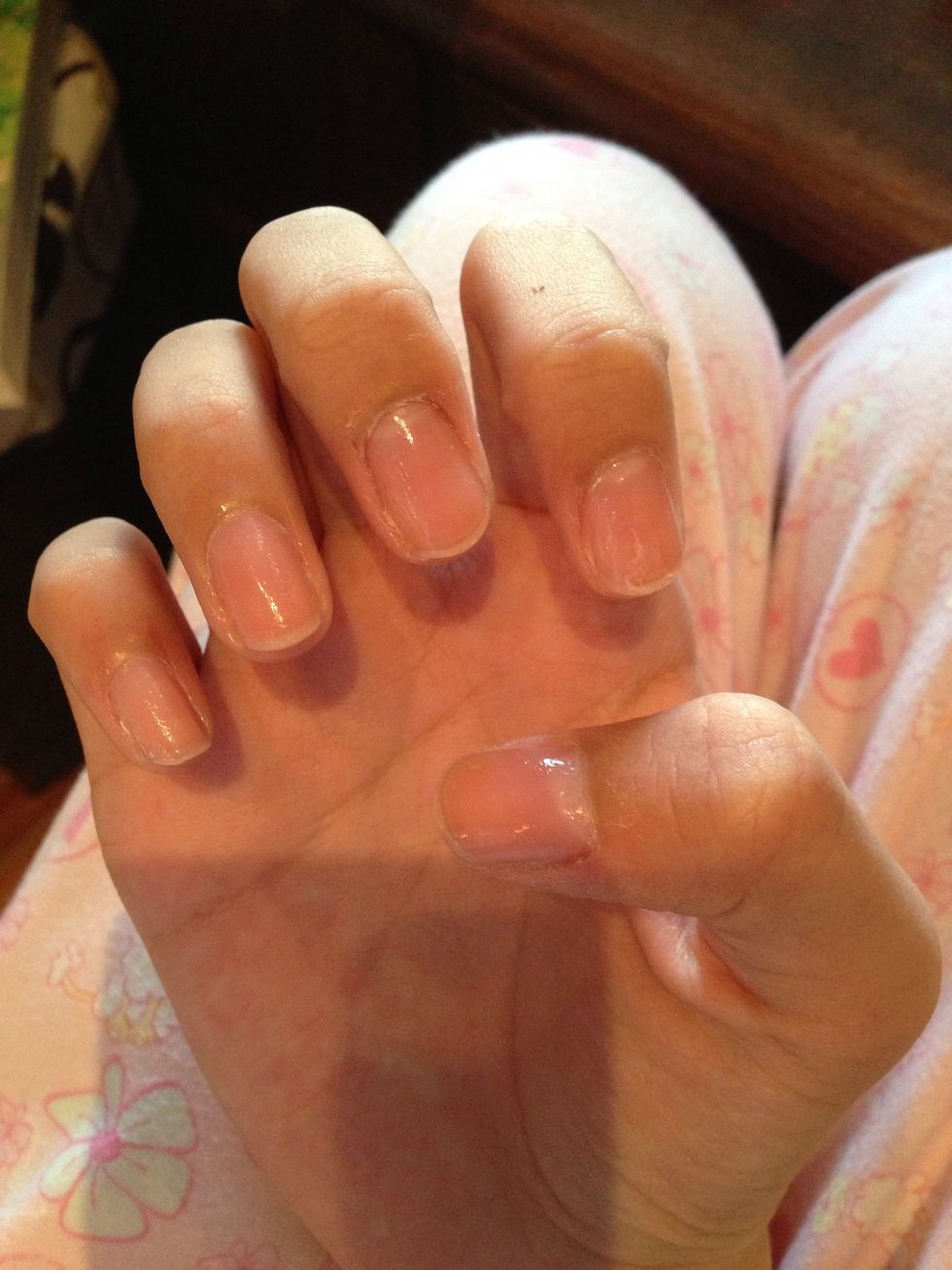 First, apply clear nail polish. You can use pale pink or beige too.