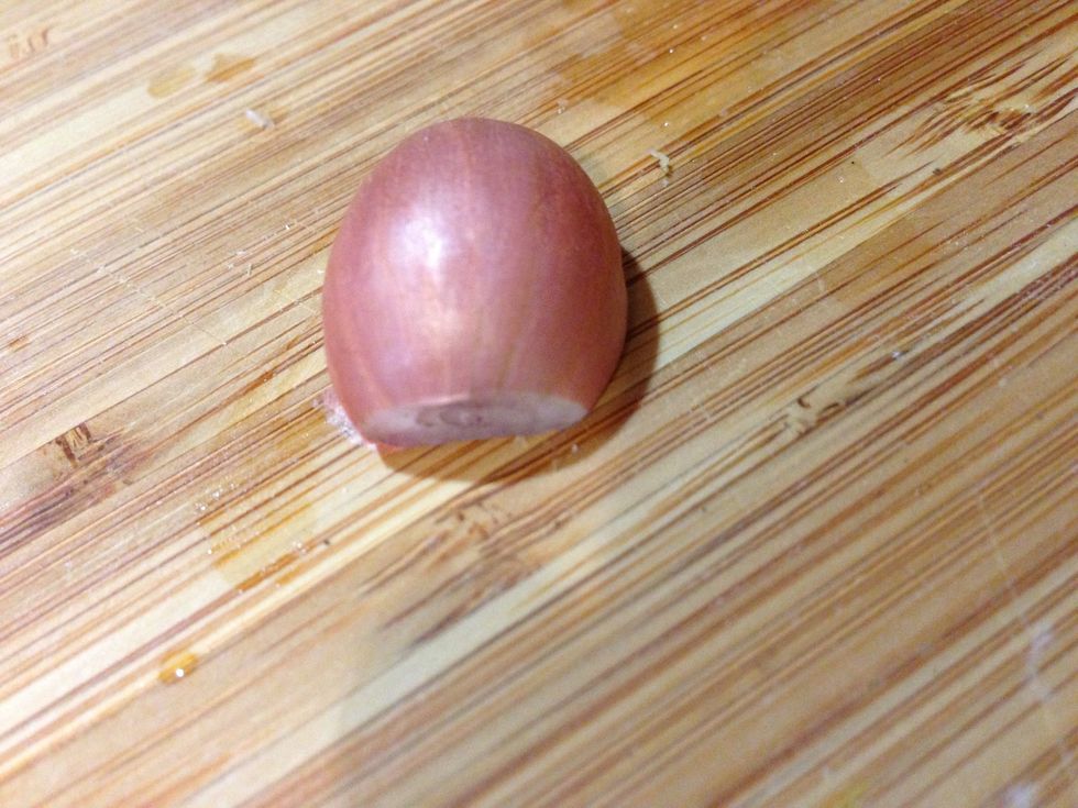 First carefully cut off both ends. Then peel off the outer layer just like an onion. If that's difficult you can slice a line down its belly and peel from there.