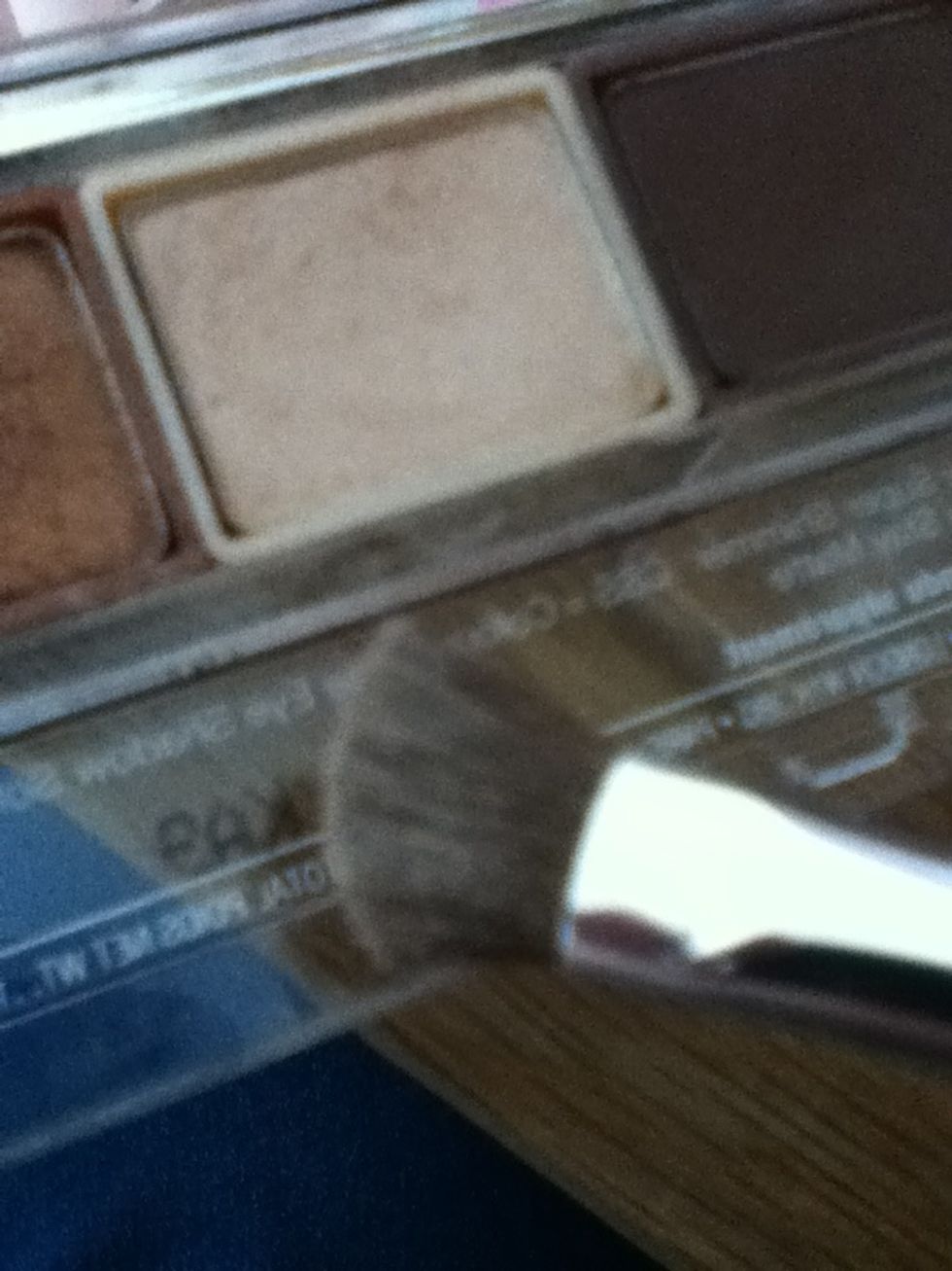 First choose a pale beige eye shadow and a medium eye shadow brush.