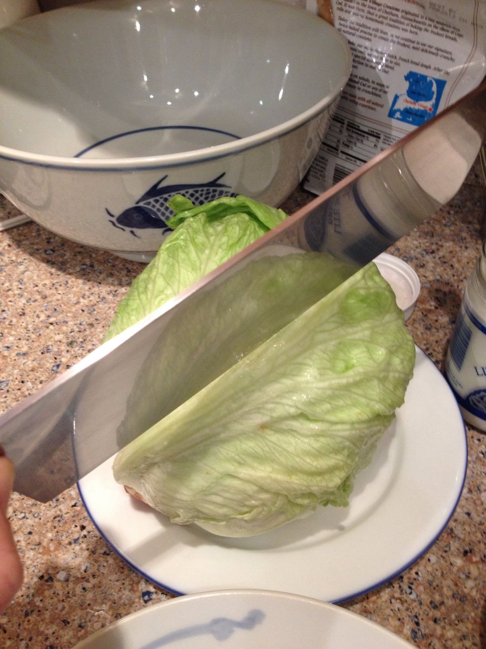 First, chop your head of lettuce in half.