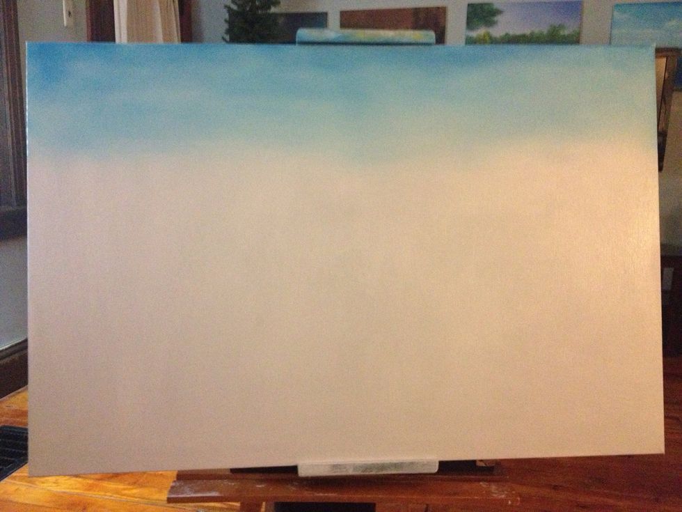 First, cover your canvas with a thinned down, even coat of gray. This will allow other colors to blend. Next, use a little blue and white on a large chip brush and paint X patterns for your sky.