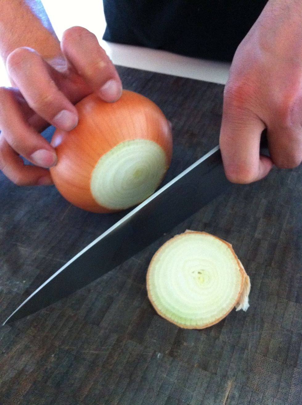 First, cut off the top tip of the onion. Leave the bottom with the root on. This will hold the onion together while you chop it up