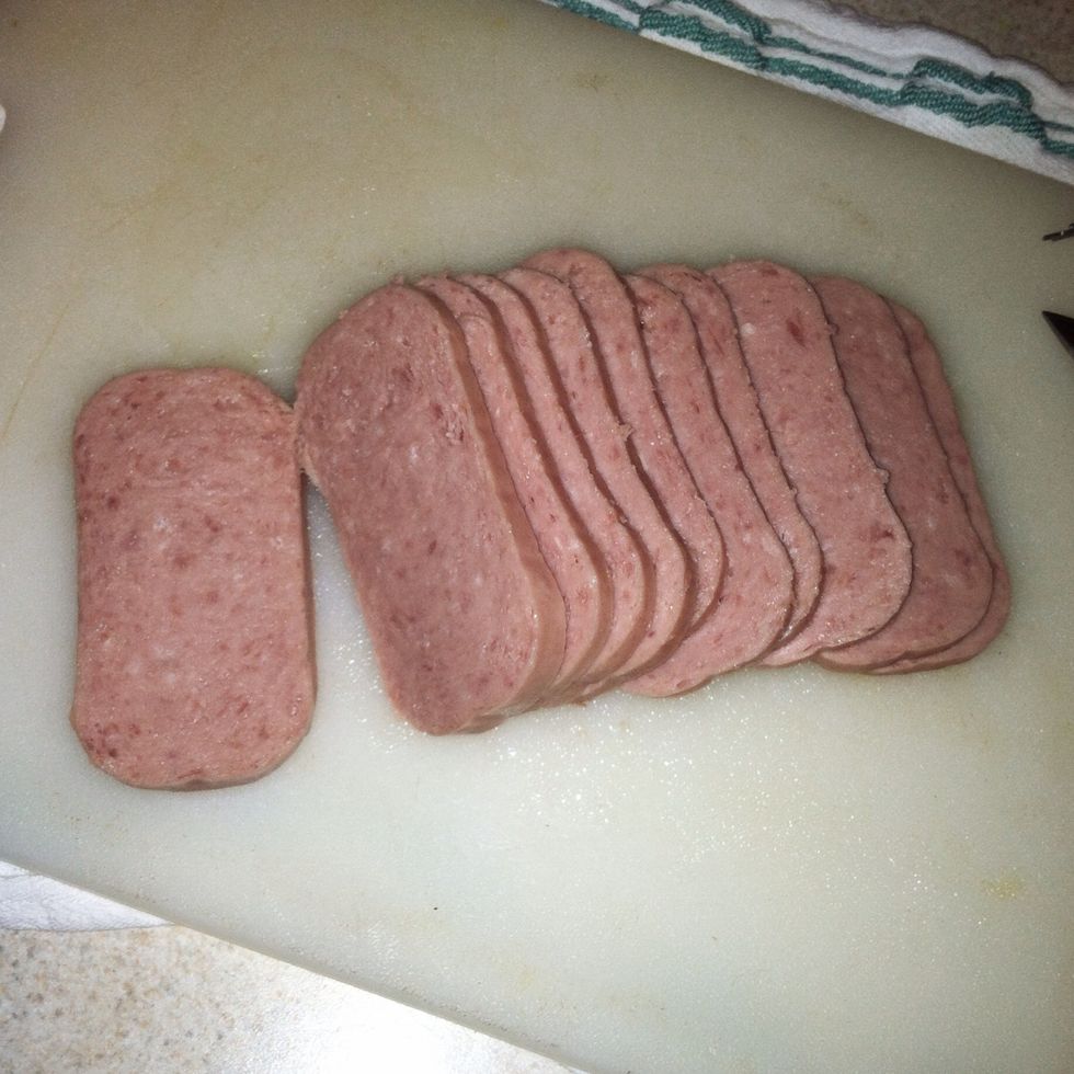 First, cut Spam into 10-12 slices. Next, mix soy sauce and sugar in a small bowl.