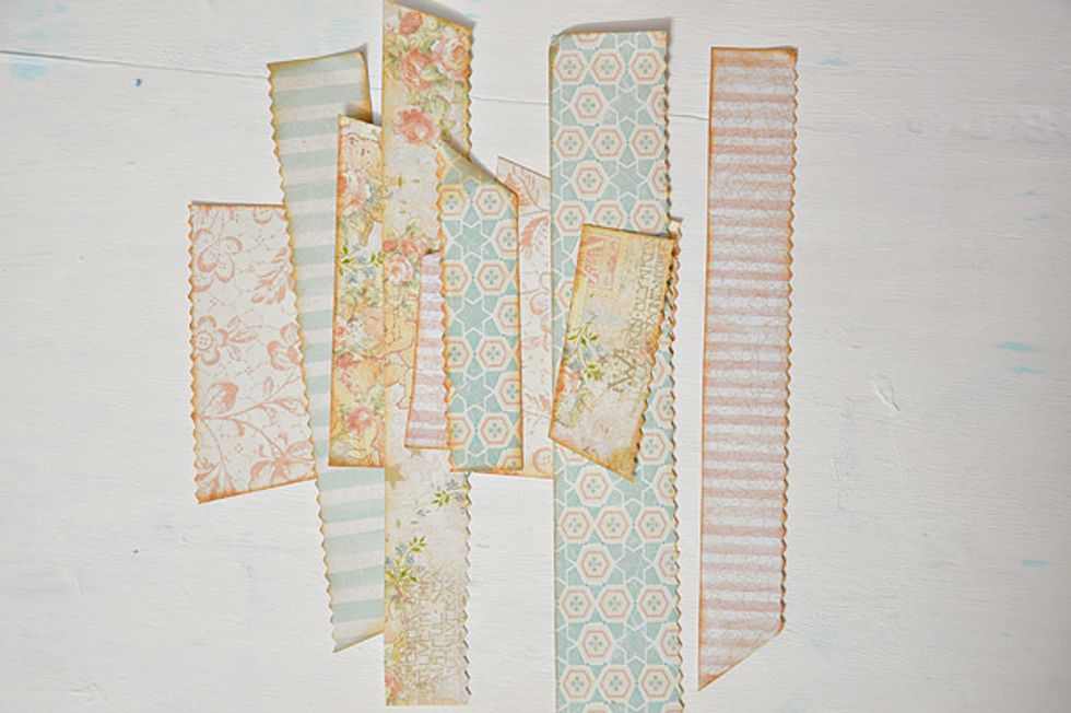 First, cut strips of papers in varying length and width. I used decorative scissors in some of the strips. Then ink the edges with distress ink of your choice. I used Tea dye.