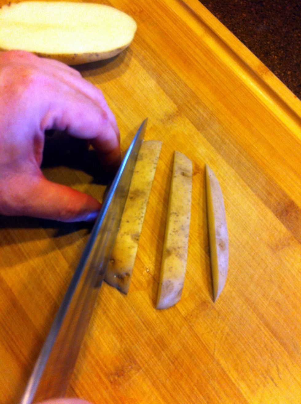 First, cut the potato in half, then cut each half into strips