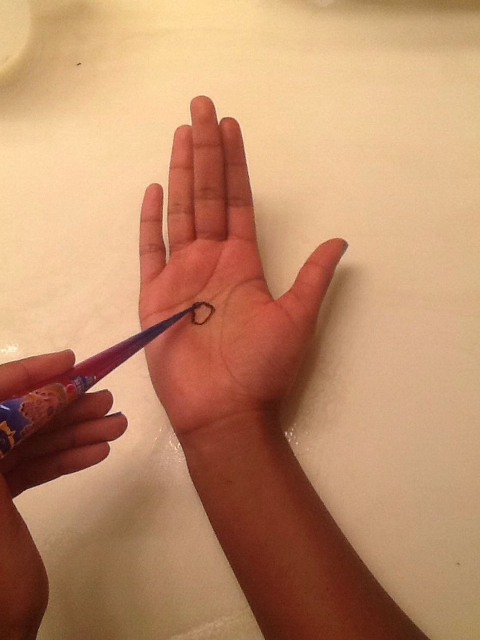 First draw a circle about 3/4 of an inch wide in the middle of your hand.