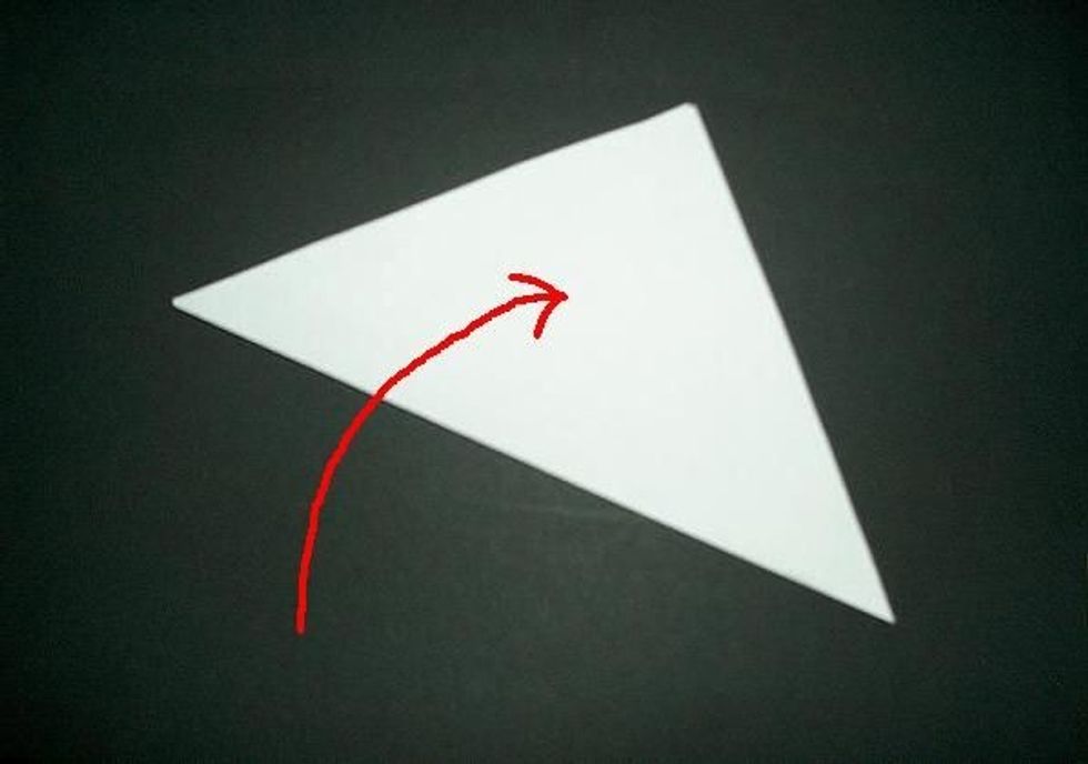 First, fold the piece of paper into a big triangle and cut off the extra paper on one of the sides.