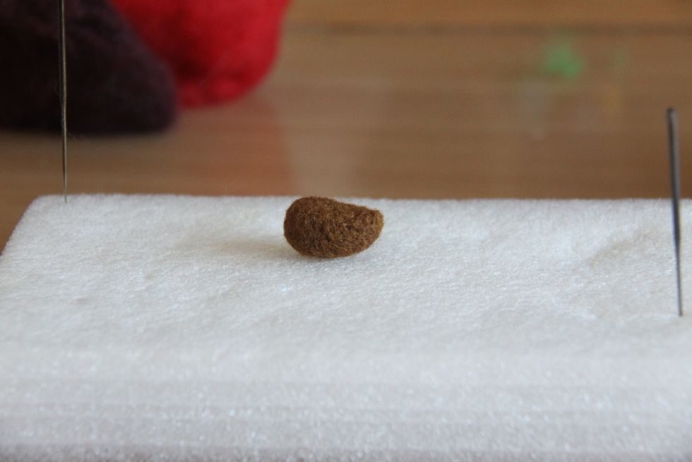 First, form an oval shape from light brown wool and punch one side in the top to achieve the shape in the picture for the head.