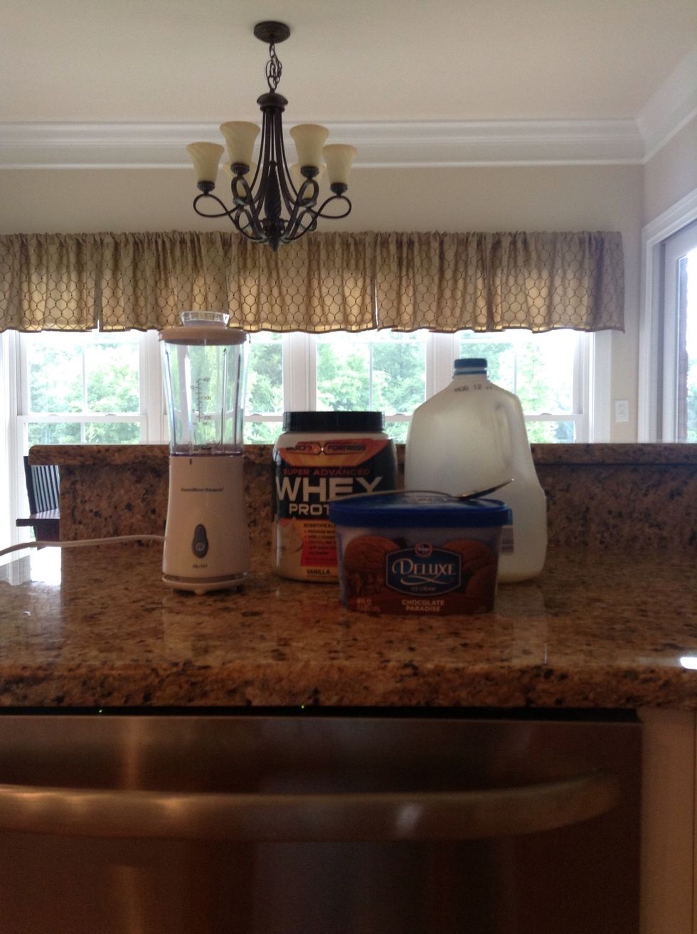 First, gather your supplies. You will need a blender, protein powder, milk, ice cream, and a tablespoon.