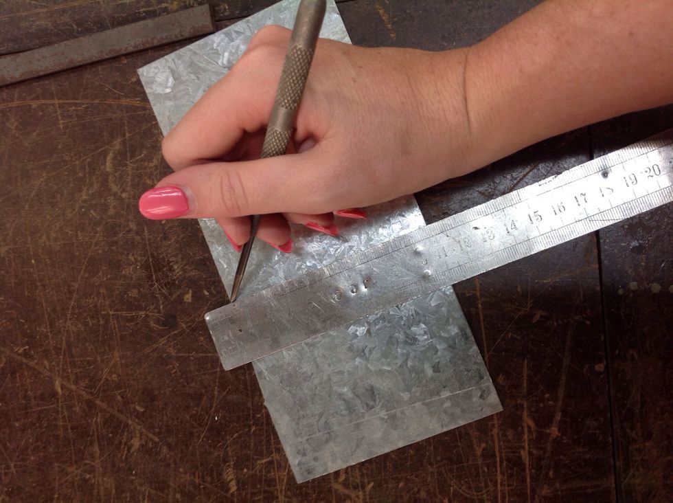 First, get a thin bit of metal like this, and get a metal ruler and a scriber, then rule a line on the metal.