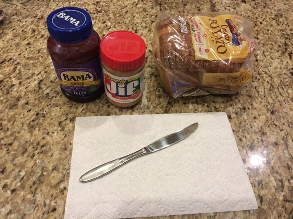 First, get all of your supplies together. You need peanut butter, jelly, bread, knife and a paper towel. I like to use grape jelly.