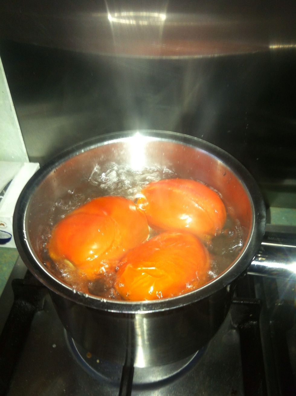 First I make fresh tomato pur\u00e9e. Boil some Roma or truss tomatoes that you have scored at one end.