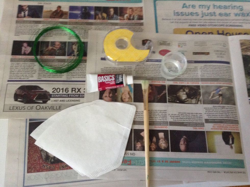 First, lay out all your supplies on a table. Also, lay out your newspaper.