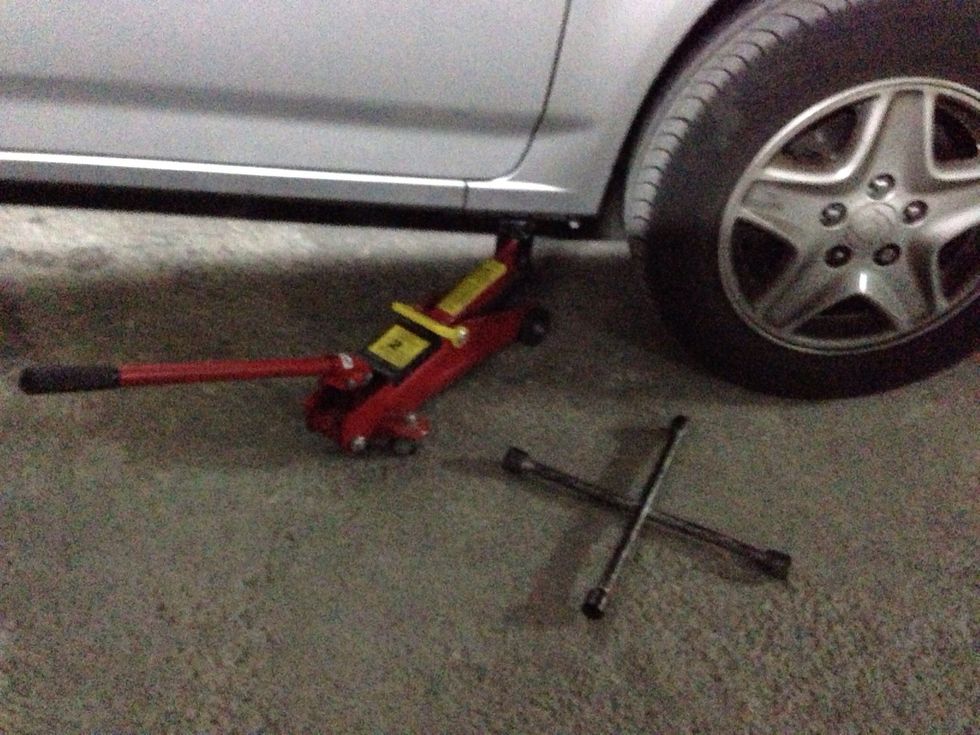 First, loosen the wheel nuts. Then raise the car.